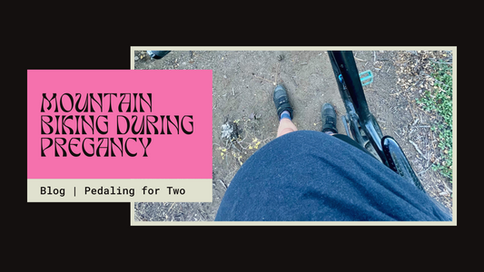 View from above of a pregnant woman on a mountain bike trail, wearing clip-in cycling shoes and standing beside her bike, belly prominently visible. Text reads: 'Mountain Biking During Pregnancy – Blog | Pedaling for Two.'