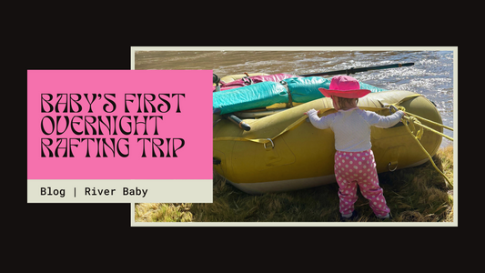 Toddler wearing a bright pink sunhat and polka dot pants stands next to a large inflatable yellow raft at the edge of a river. Text reads: 'Baby’s First Overnight Rafting Trip – Blog | River Baby.'