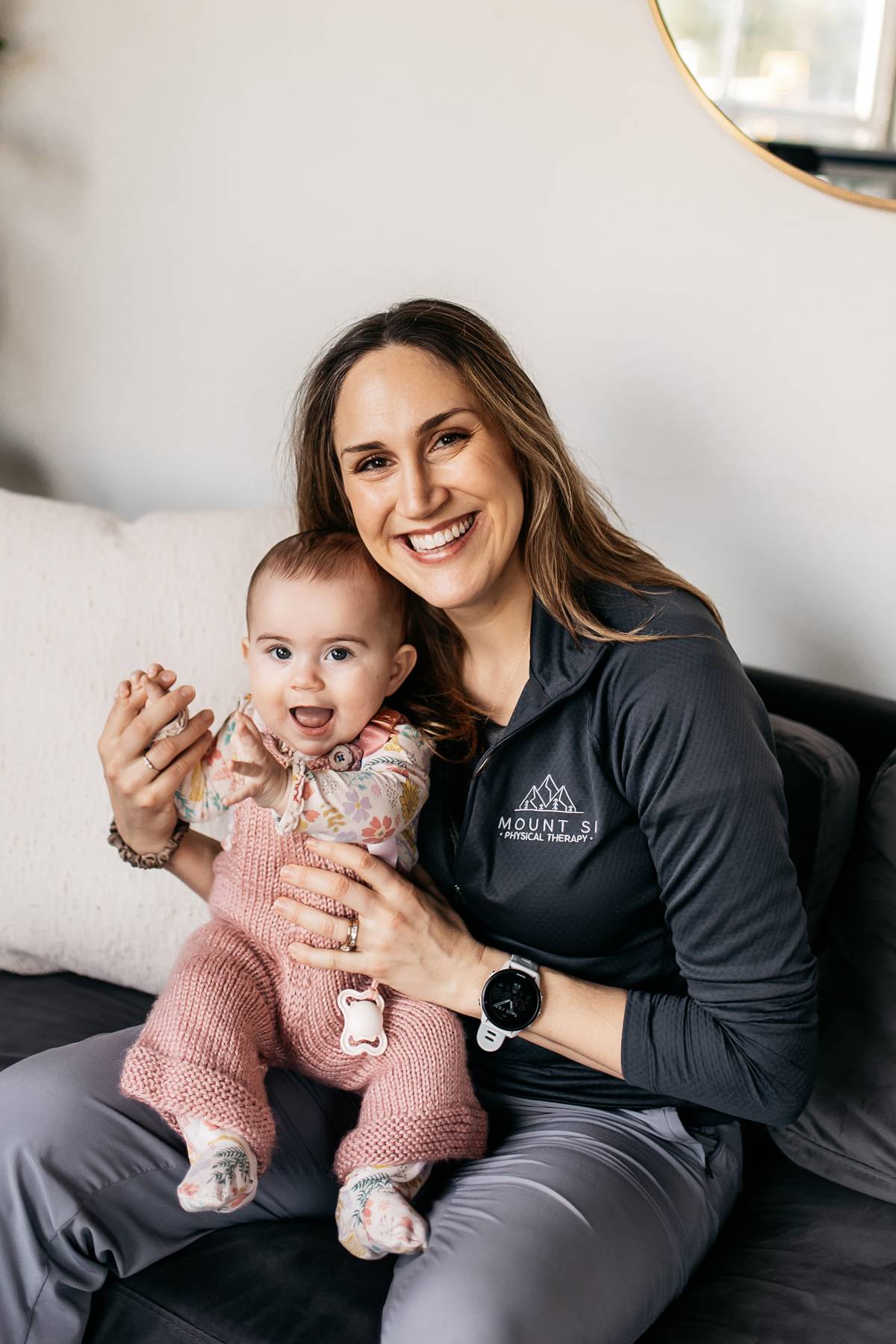 Pelvic floor therapist smiling with baby